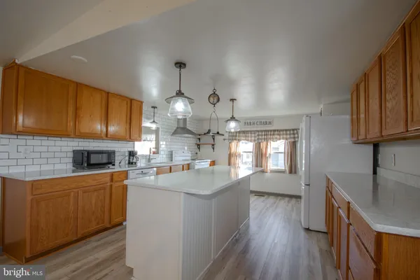 a kitchen with cabinets wooden floor and stainless steel appliances