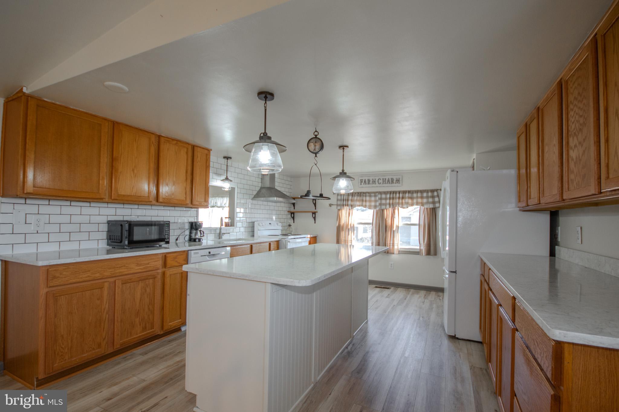 6761 Sharptown Road Laurel, DE 19956 - Photo 9 of 34 a kitchen with cabinets wooden floor and stainless steel appliances