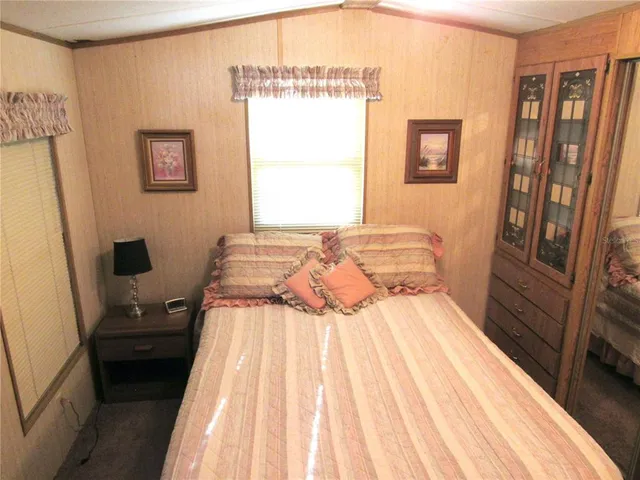 a bedroom with a bed and a flat tv screen on the dresser