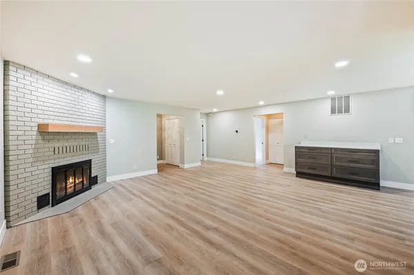 a view of empty room with wooden floor and fireplace