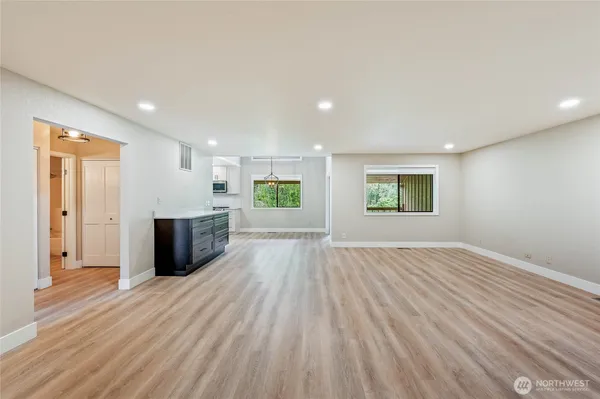 a view of a room with wooden floor and windows