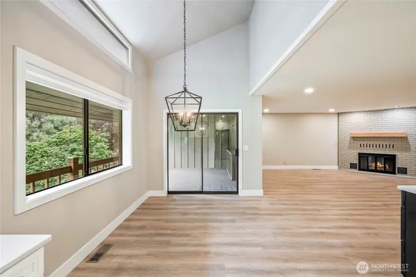 a view of a room with wooden floor fireplace and windows