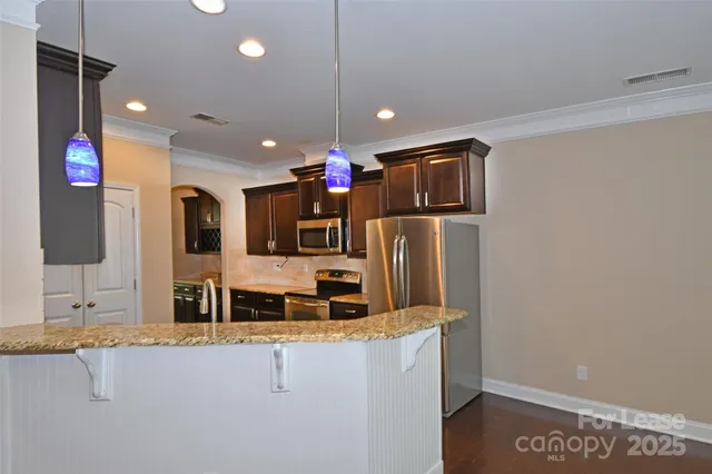 a kitchen with stainless steel appliances granite countertop a refrigerator and a sink