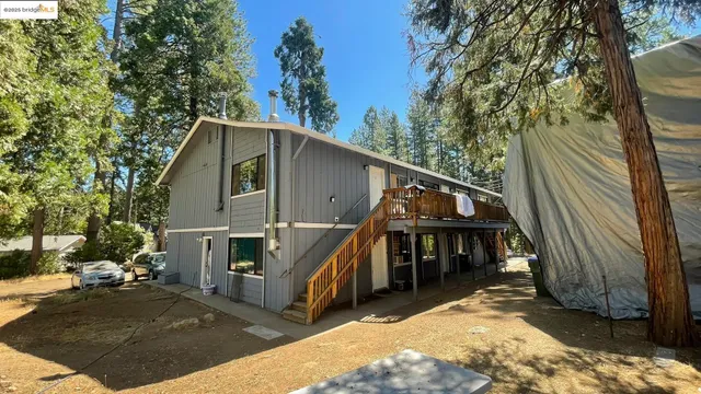 a view of house with backyard and trees