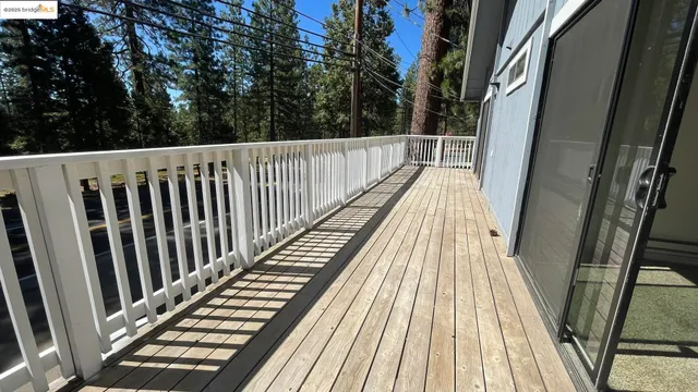 a view of balcony with wooden floor and fence