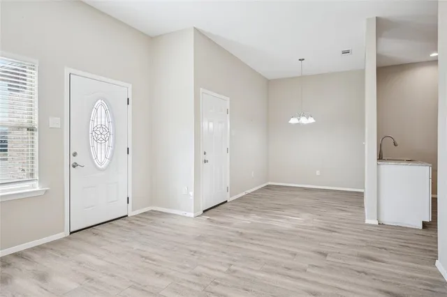 a view of a room with wooden floor and chandelier