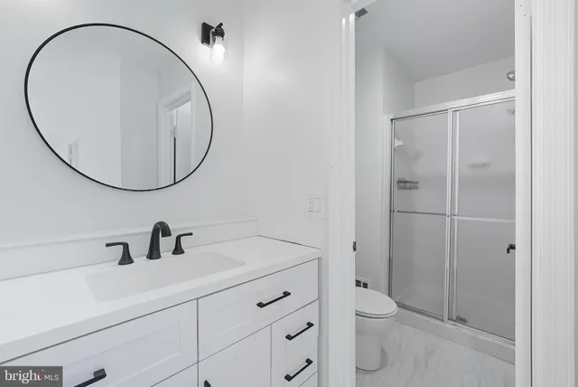 a bathroom with a sink a toilet and a mirror