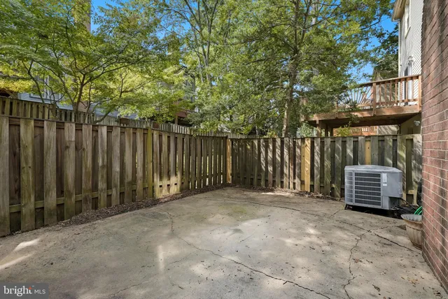 a backyard of a house with barbeque oven and trees