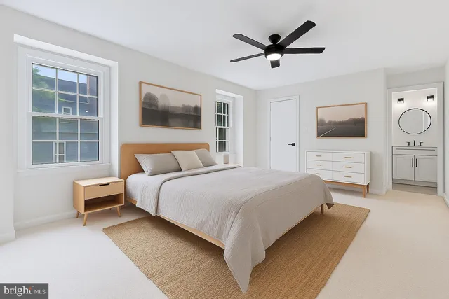 a bedroom with a bed a window and a flat screen tv