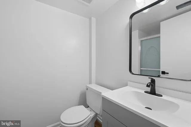 a bathroom with a sink a toilet and mirror