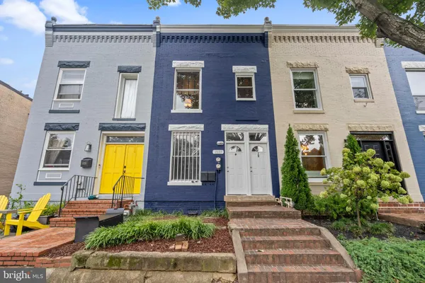 a front view of a house with garden and plants