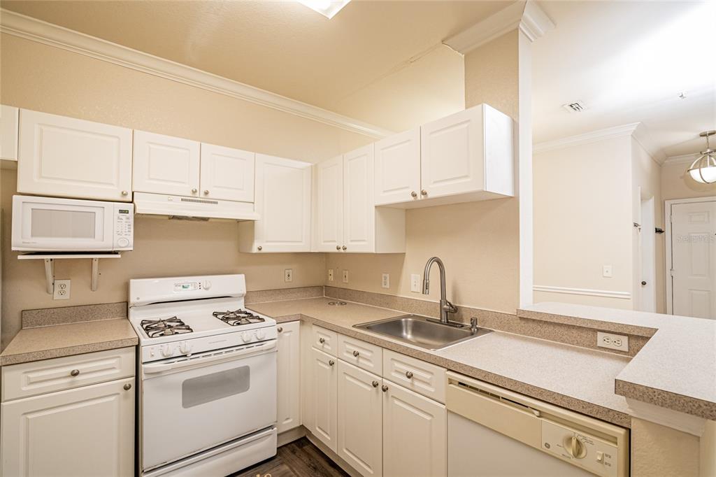 3391 South Kirkman Road, Unit 1216 Orlando, FL 32811 - Photo 10 of 33 a kitchen with cabinets appliances a sink and a counter top space