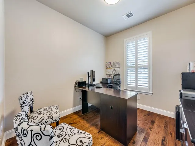 a view of a workspace with furniture and a window