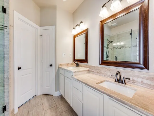 a bathroom with double sink and a mirror