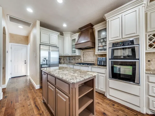 a kitchen with stainless steel appliances granite countertop a stove and a refrigerator