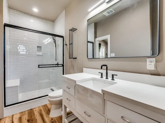 a bathroom with a sink a toilet and shower