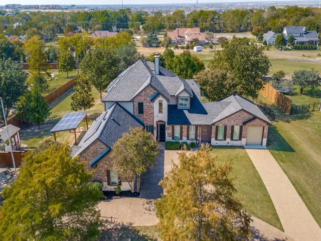 an aerial view of residential houses with outdoor space and trees