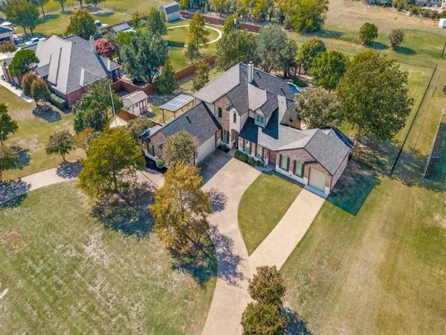 an aerial view of a swimming pool with outdoor seating and yard