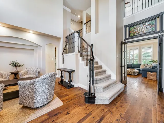 a living room with furniture and a view of staircase with wooden floor