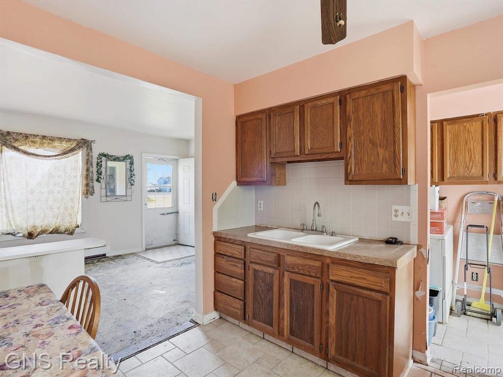 2717 Normandy Road Royal Oak, MI 48073 - Photo 11 of 13 Kitchen featuring wood cabinetry, a dual basin sink, and white tile backsplash