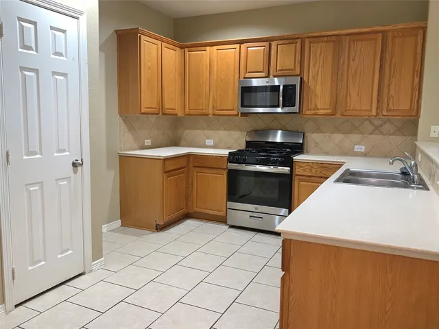 a kitchen with granite countertop a sink and a stove top oven