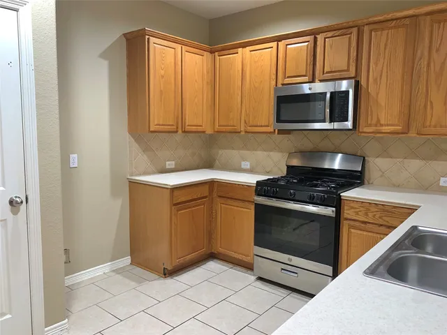 a kitchen with stainless steel appliances granite countertop a stove and a microwave