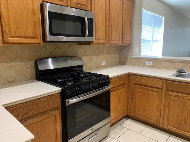 a kitchen with granite countertop cabinets and steel stove top oven