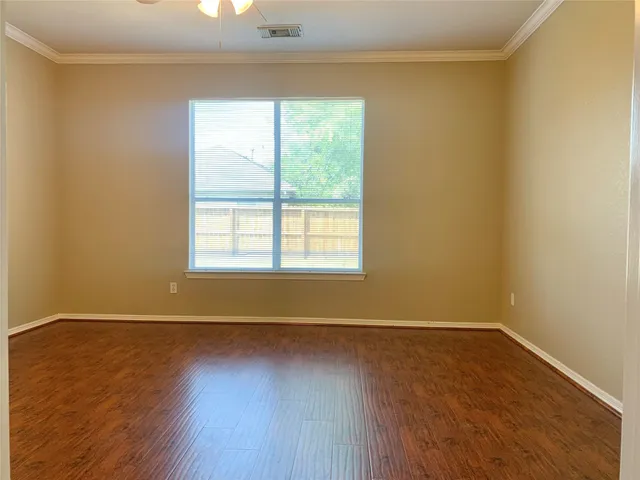 a view of a room with wooden floor and a window