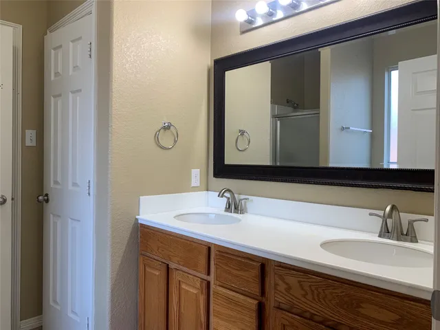 a bathroom with a double vanity sink and a mirror
