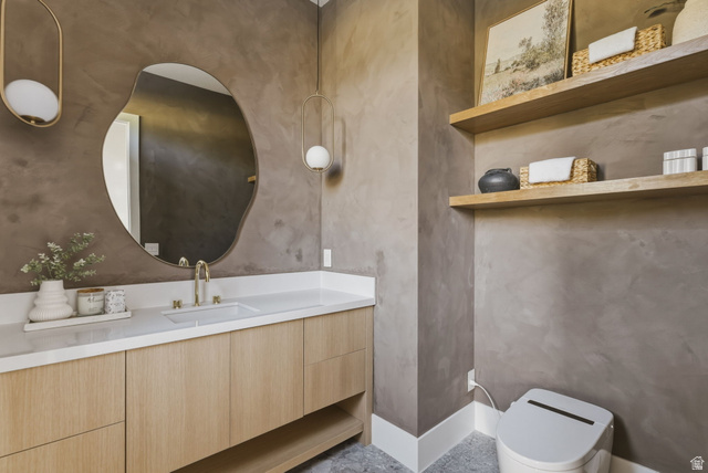 923 North Emery Lane Elk Ridge, UT 84651 - Photo 77 of 101 Vanity area featuring a light wood-finish cabinetry, a white countertop with an integrated sink, and a gold-tone faucet