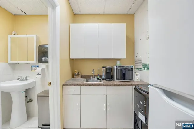 a kitchen with granite countertop a sink stainless steel appliances and white cabinets