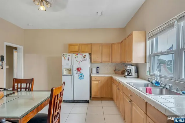 a kitchen with stainless steel appliances granite countertop a table chairs sink and cabinets