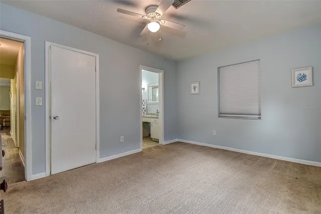 an empty room with closet and fan