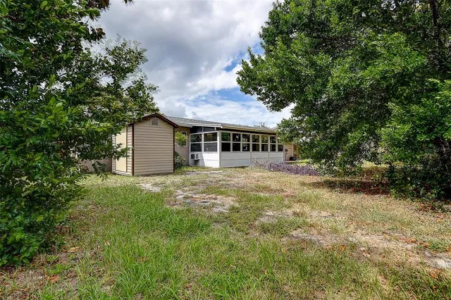 an aerial view of residential houses with outdoor space and trees