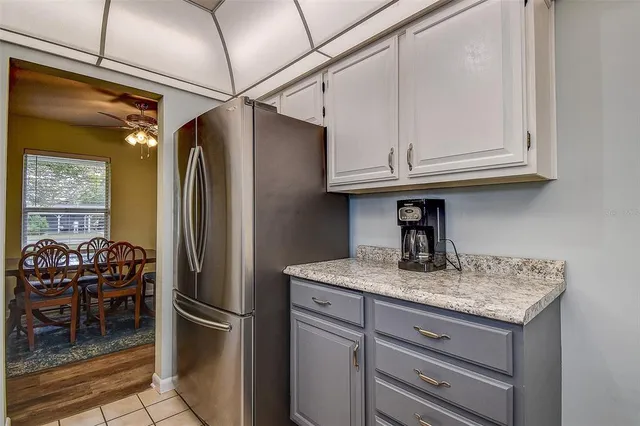a kitchen with stainless steel appliances granite countertop a refrigerator and a white cabinets