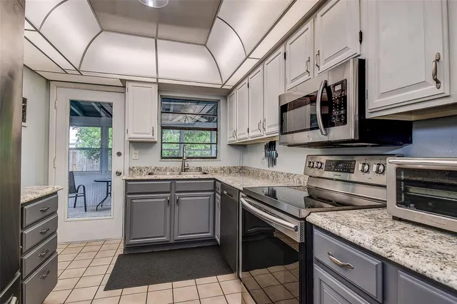 a kitchen with stainless steel appliances granite countertop a sink and stove top oven