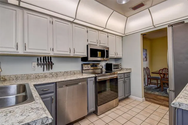 a kitchen with stainless steel appliances granite countertop a sink stove and microwave