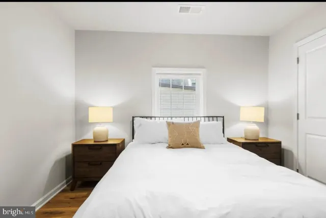 a bedroom with a bed and wooden floor