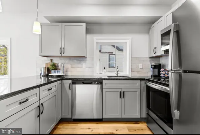 a kitchen with stainless steel appliances granite countertop a sink stove and cabinets