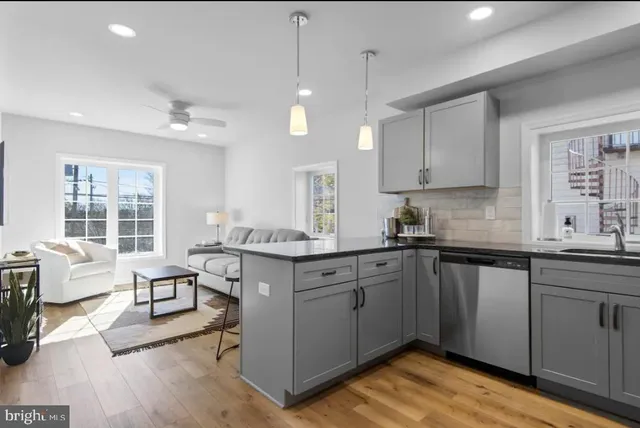 a kitchen with granite countertop a sink cabinets and wooden floor