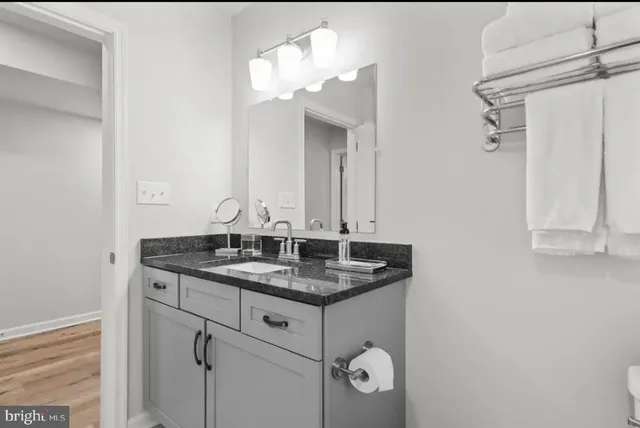 a bathroom with a granite countertop sink and a mirror