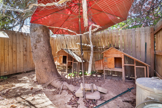 576 East 3950 North Provo, UT 84604 - Photo 44 of 47 Fenced backyard area featuring mature trees and two wooden chicken coops