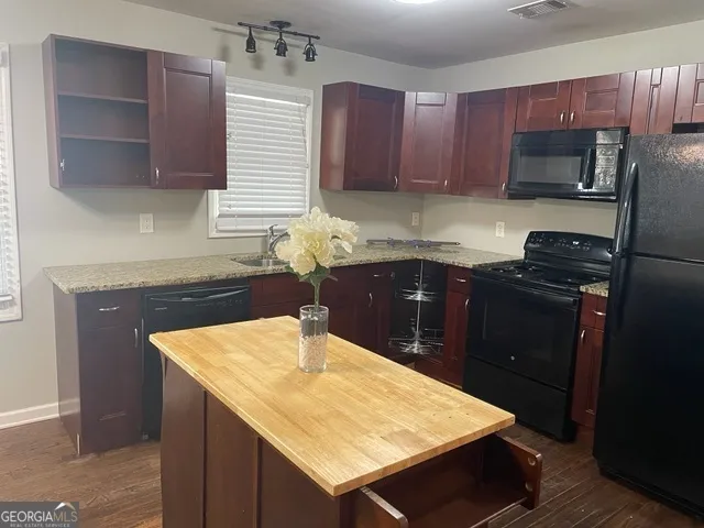 a kitchen with a sink a microwave and cabinets