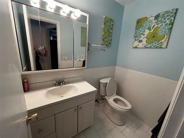 a bathroom with a sink mirror vanity and toilet