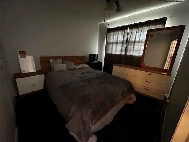 a bedroom with a bed closet and mirror