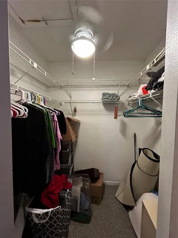 a view of walk in closet with clothes and shoes