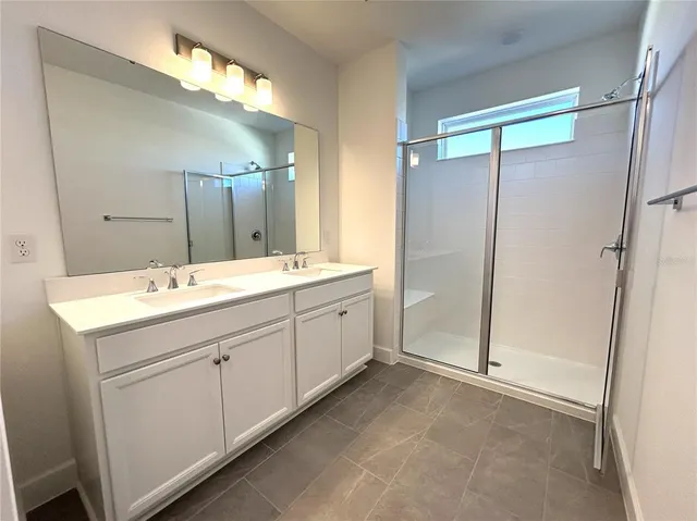 a spacious bathroom with a double vanity sink mirror and double