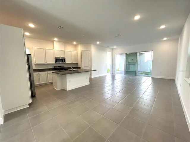 a kitchen with stainless steel appliances a refrigerator a stove a microwave and a sink