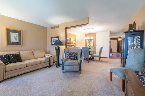 a living room with stainless steel appliances kitchen island granite countertop furniture and a wooden floor