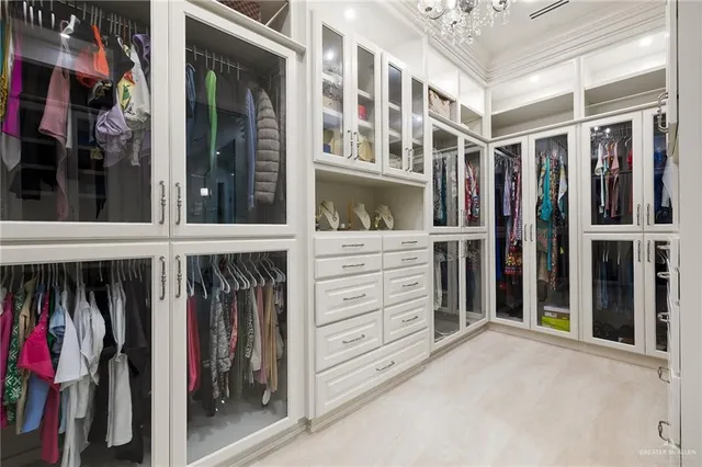 a view of walk in closet with clothes and shoes